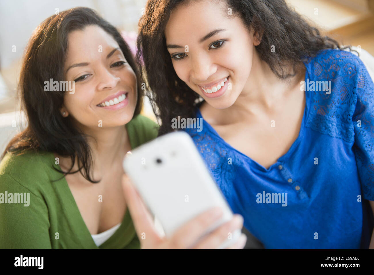 Mutter und Tochter unter Bild mit Handy Stockfoto