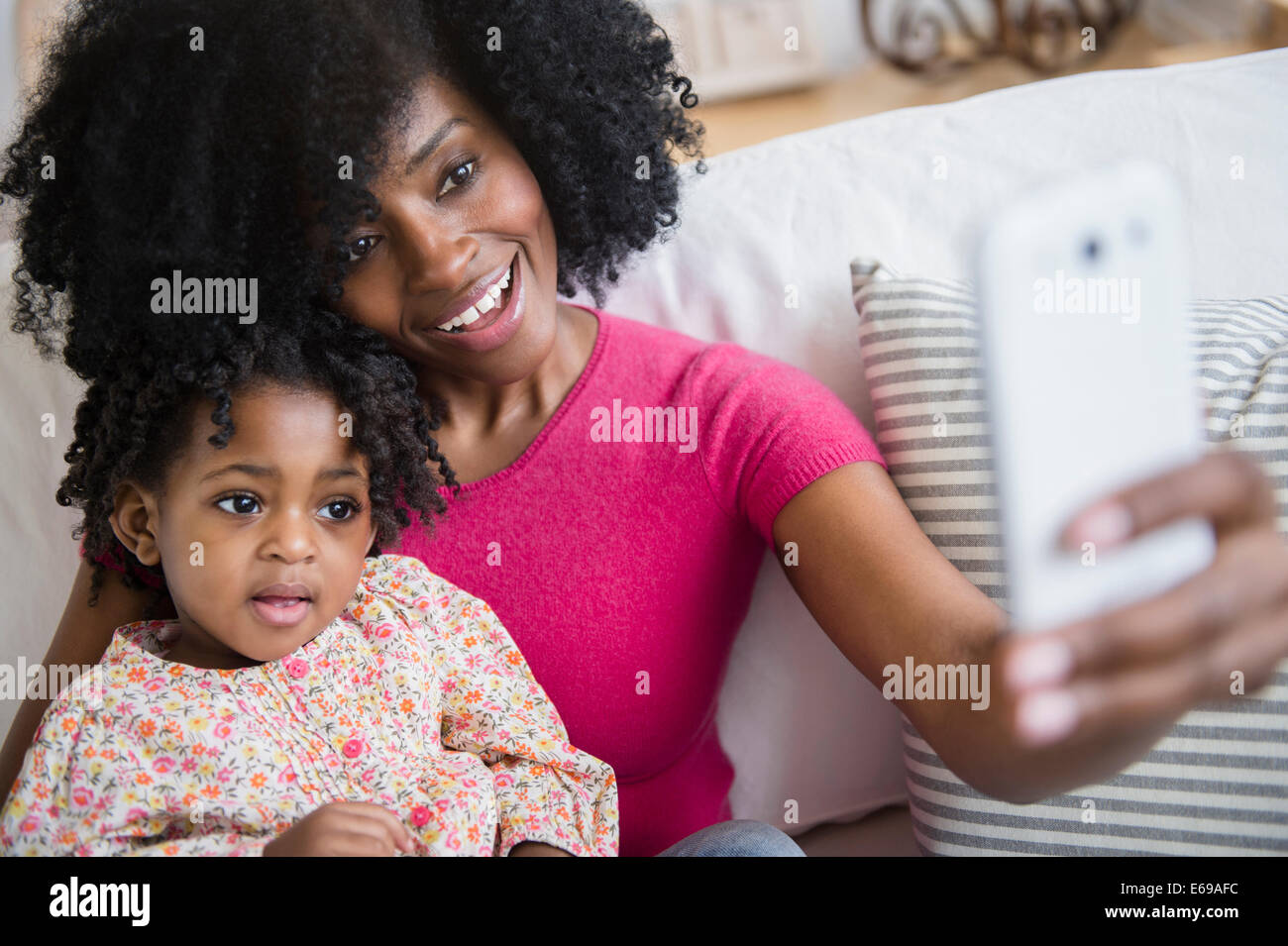 Mutter nehmen Foto mit Tochter auf sofa Stockfoto