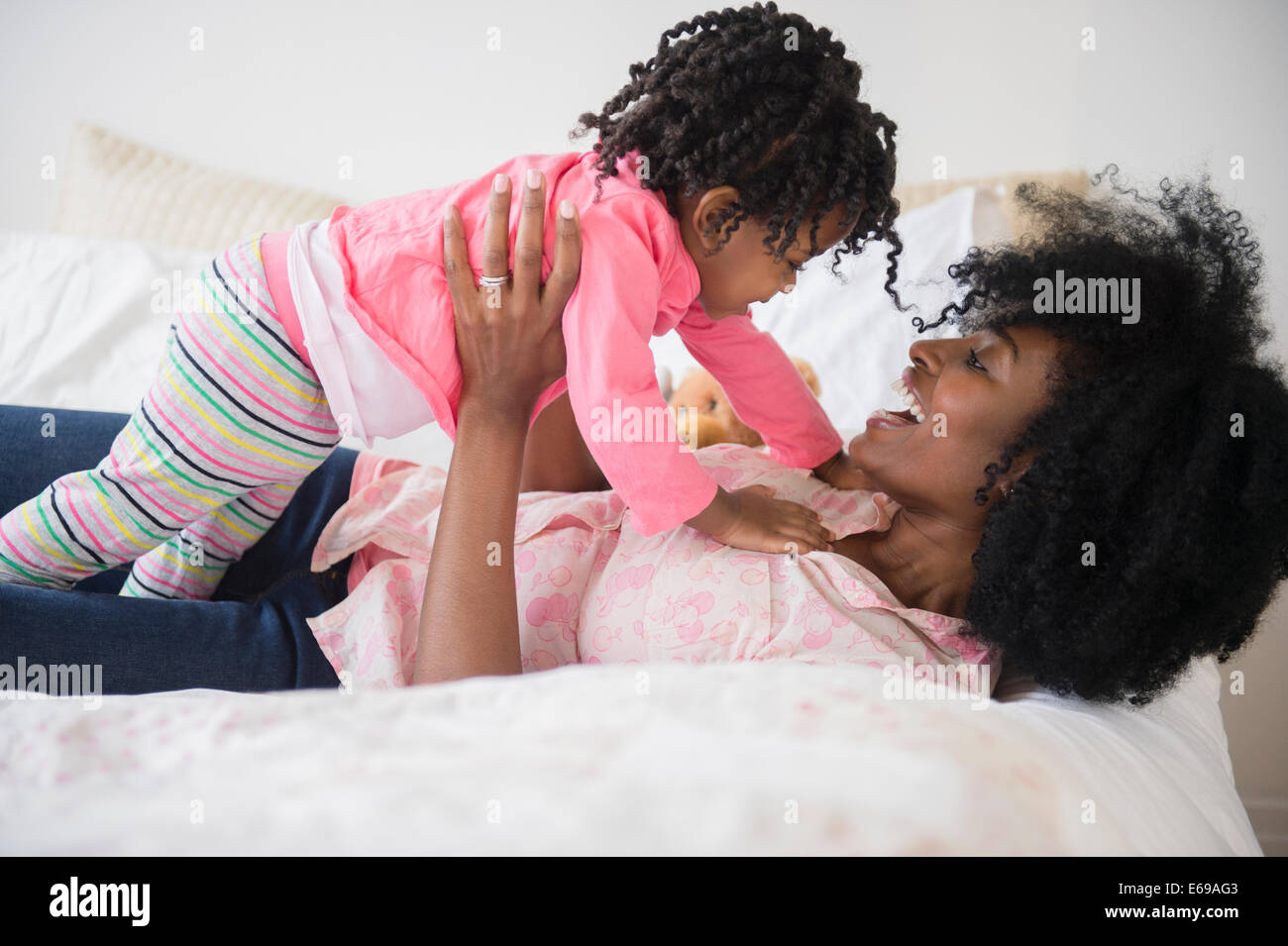 Mutter und Tochter spielen auf Bett Stockfoto