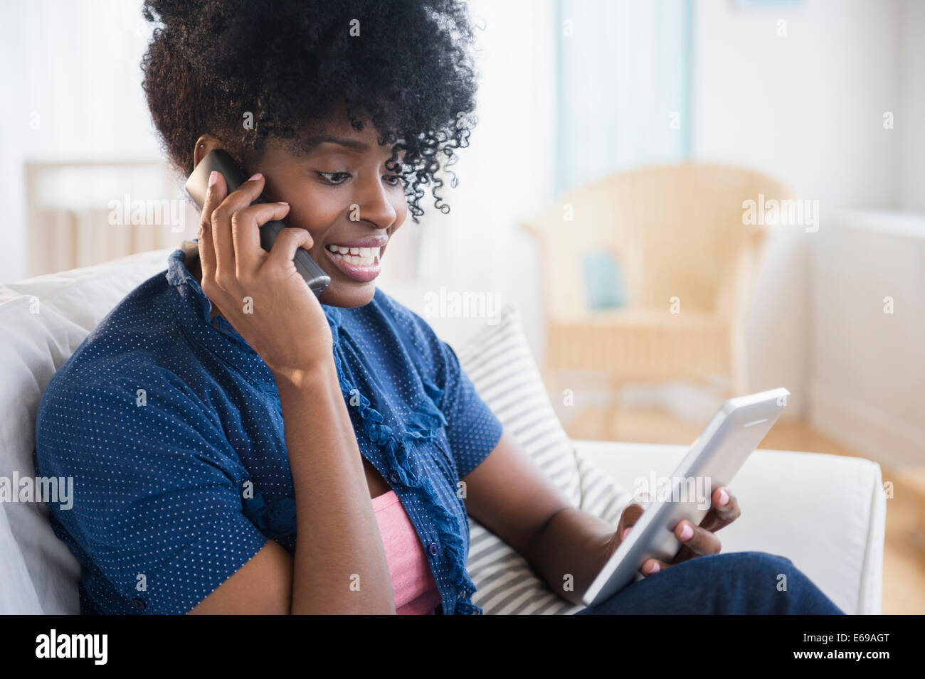 Schwarze Frau über Tablet PC auf Handy Stockfoto
