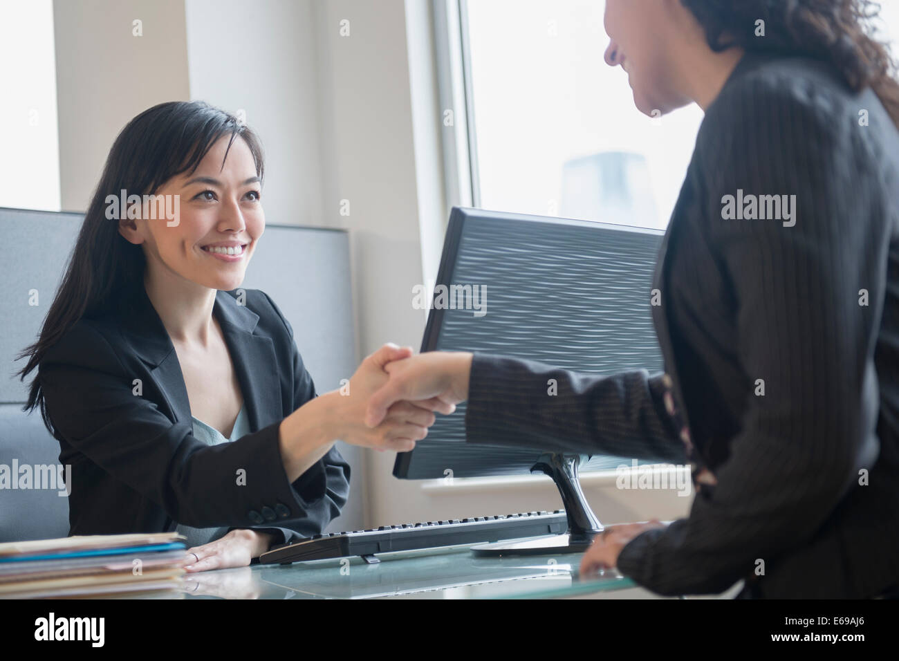Geschäftsfrauen Händeschütteln im Büro Stockfoto