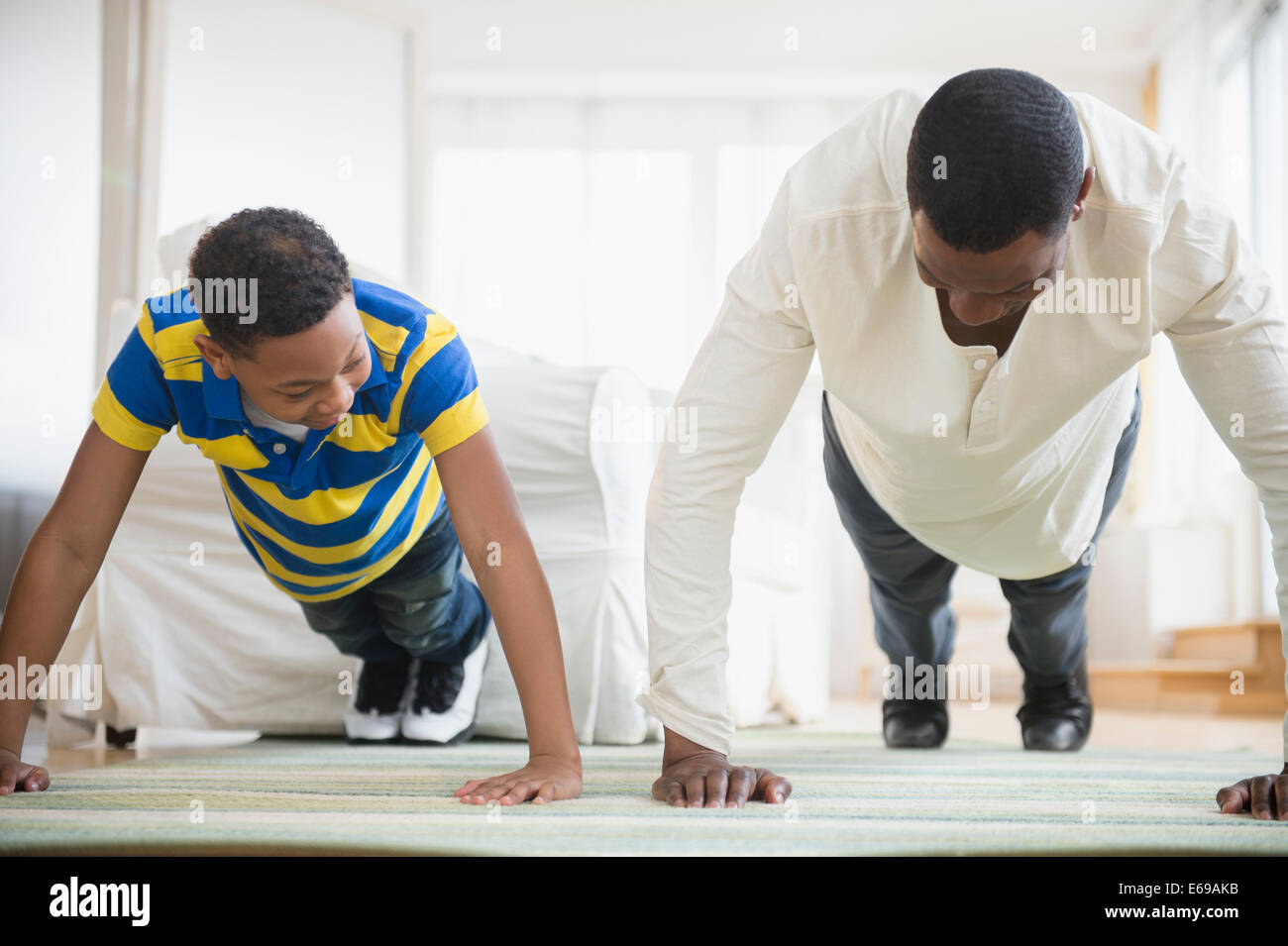 Vater und Sohn tun Push ups zusammen Stockfoto