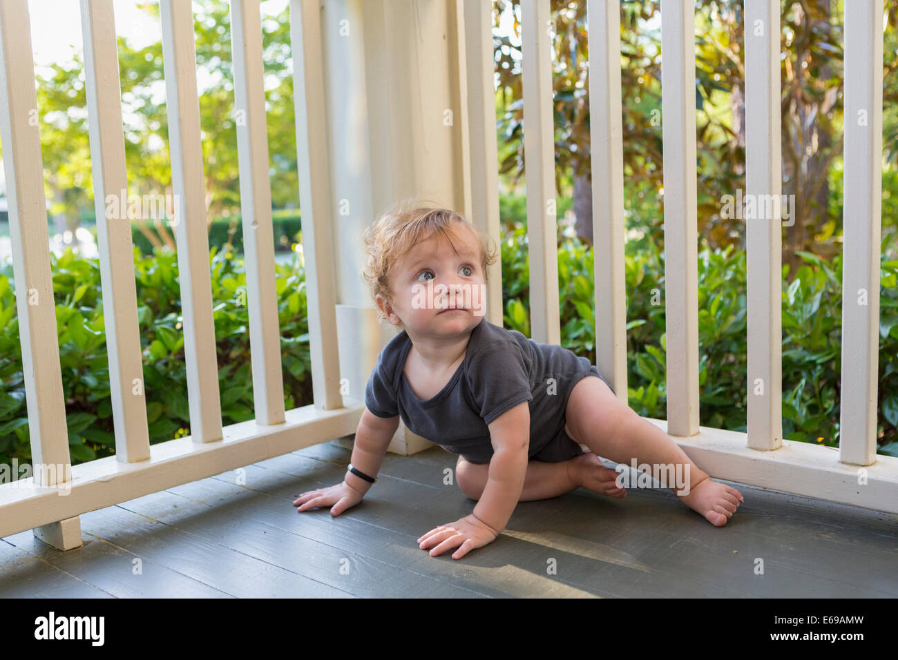 Kaukasische Baby krabbeln auf Veranda Stockfoto