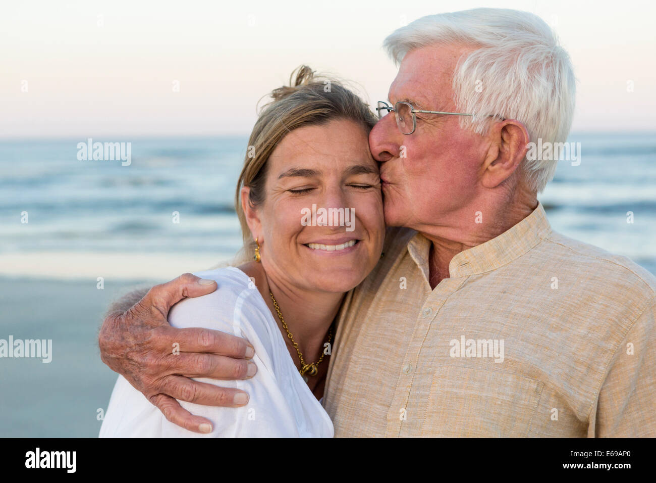 Kaukasische Vater Tochter am Strand küssen Stockfoto