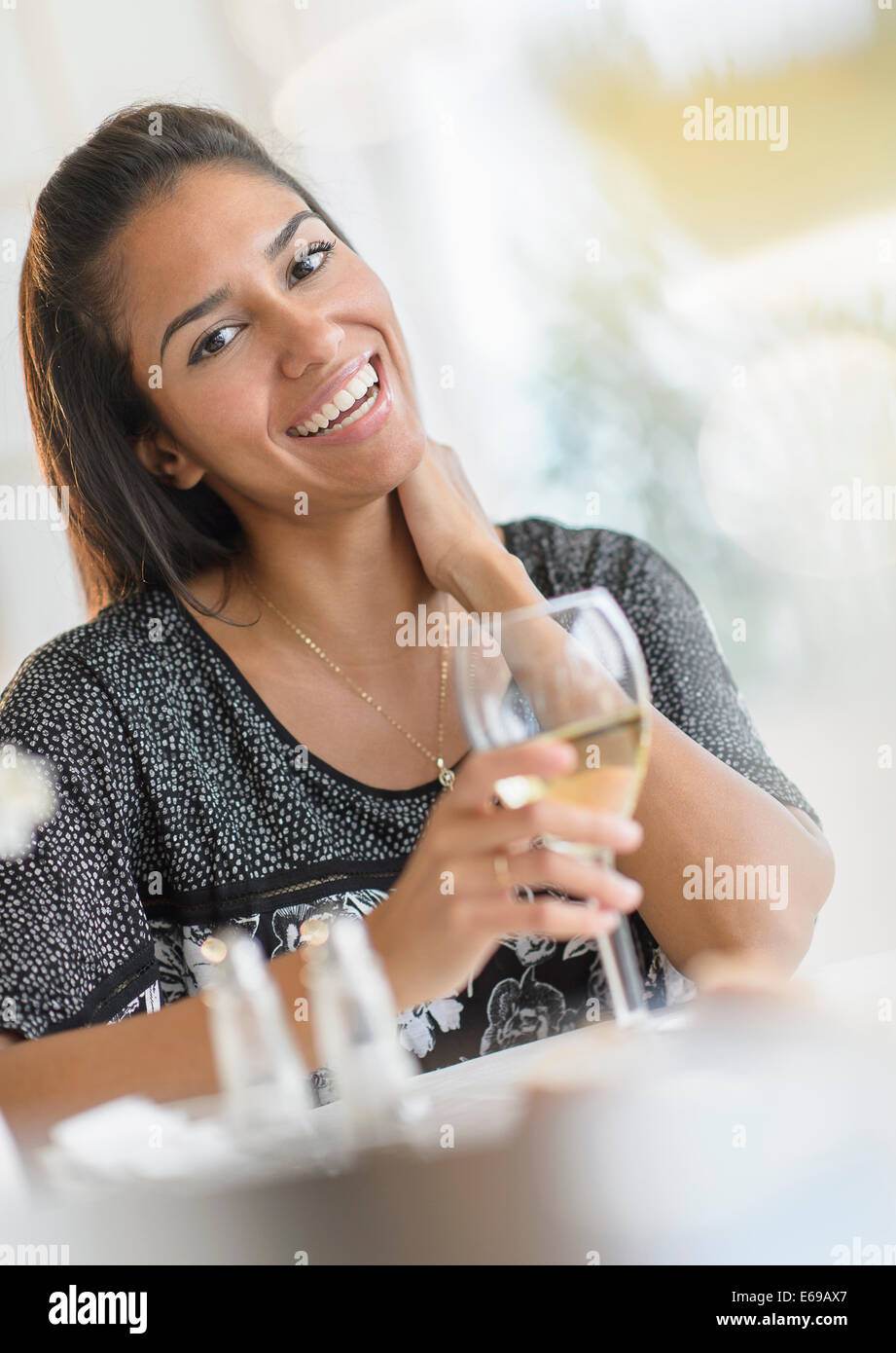 Hispanic Frau trinkt Wein beim Abendessen Stockfoto