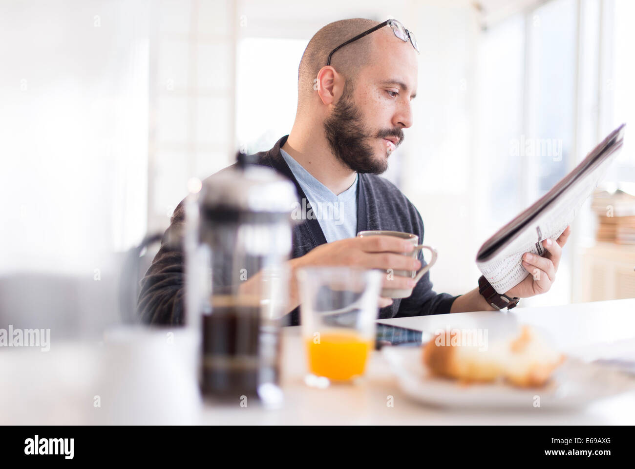 Hispanic Mann liest Zeitung beim Frühstück Stockfoto