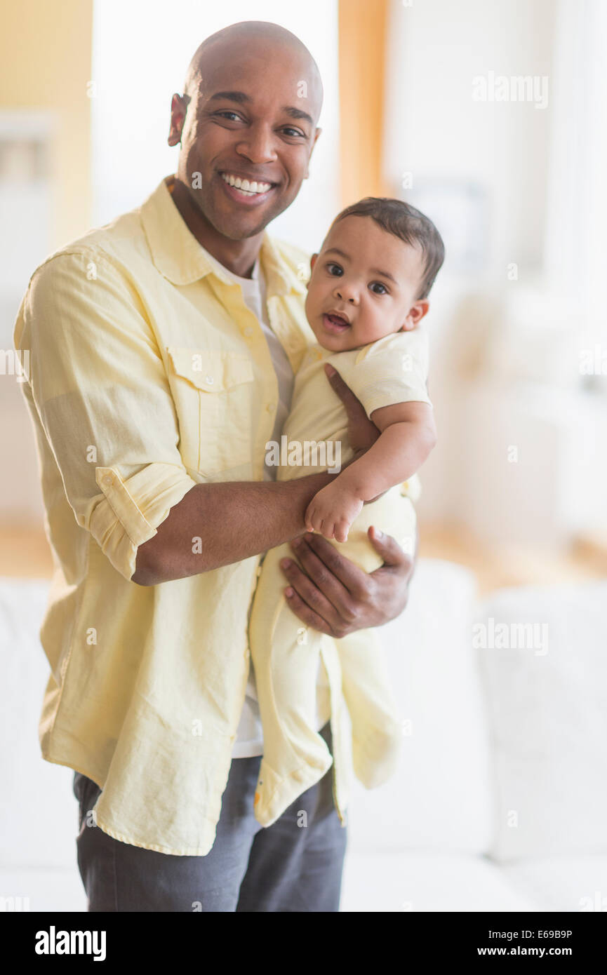 Lächelnd hält Baby Vater Stockfoto
