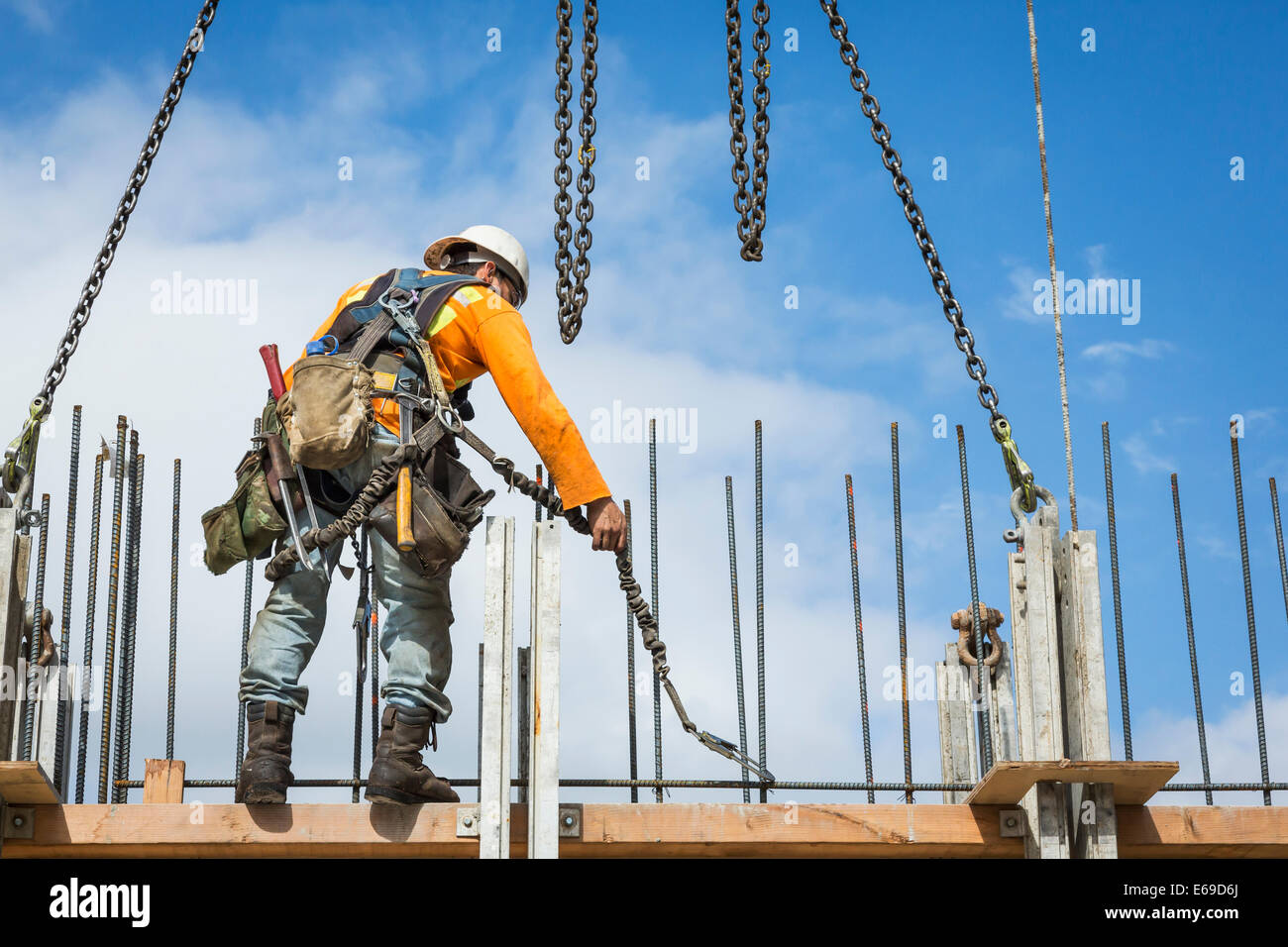 Kaukasische Arbeiter halten Kette auf Baustelle Stockfoto