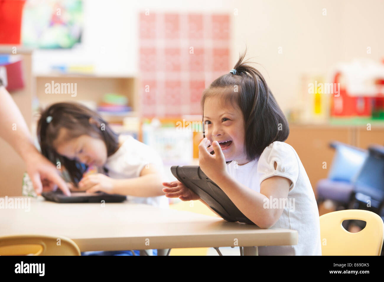 Gemischte Rassen Down Syndrom Student mit Tablet-Computer im Klassenzimmer Stockfoto