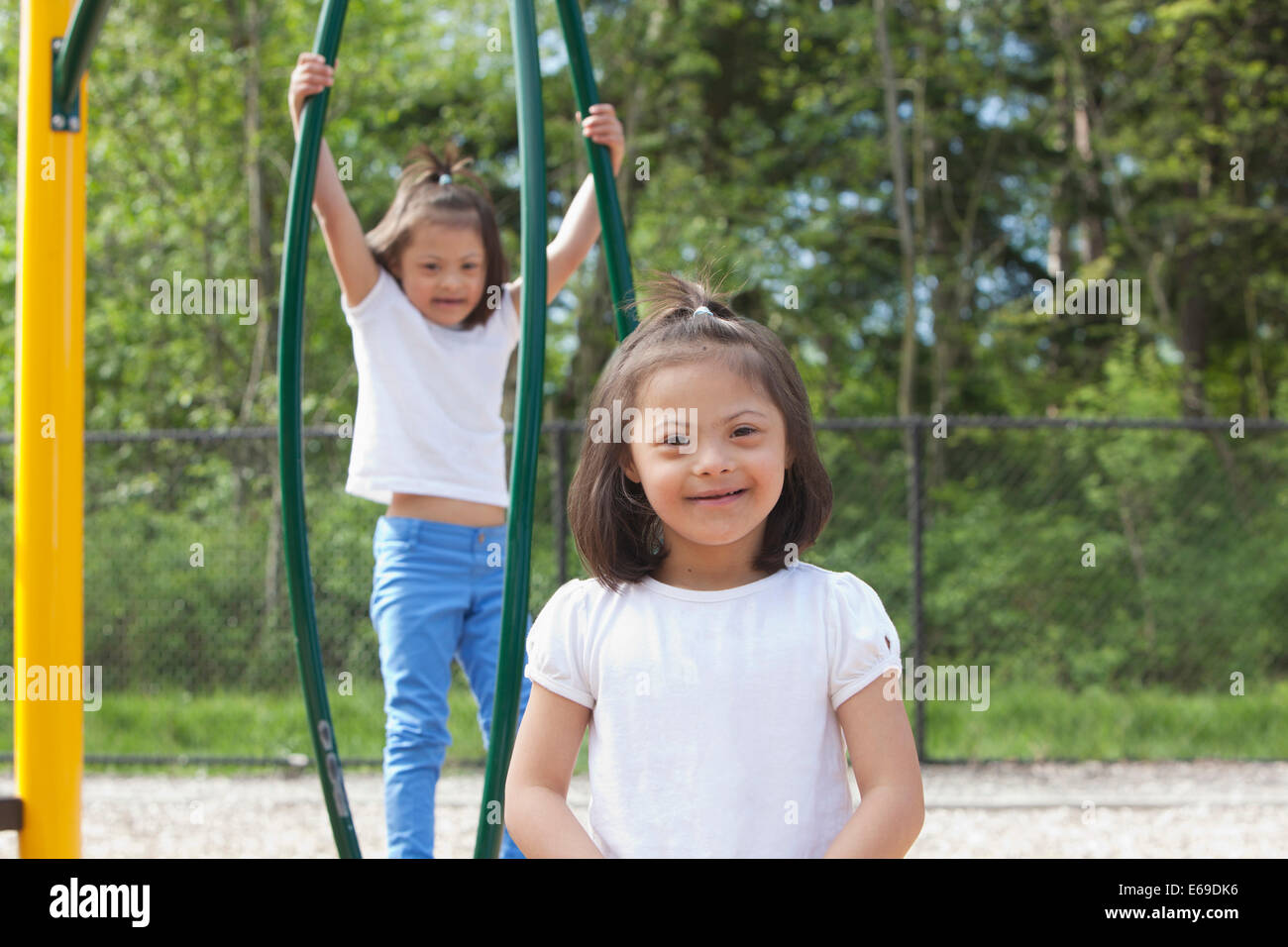 Gemischte Rassen Down Syndrom Mädchen lächelnd auf Spielplatz Stockfoto