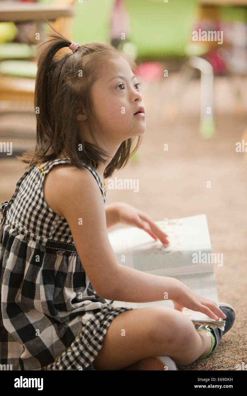 Gemischte Rassen Down Syndrom Student am Boden Stockfoto