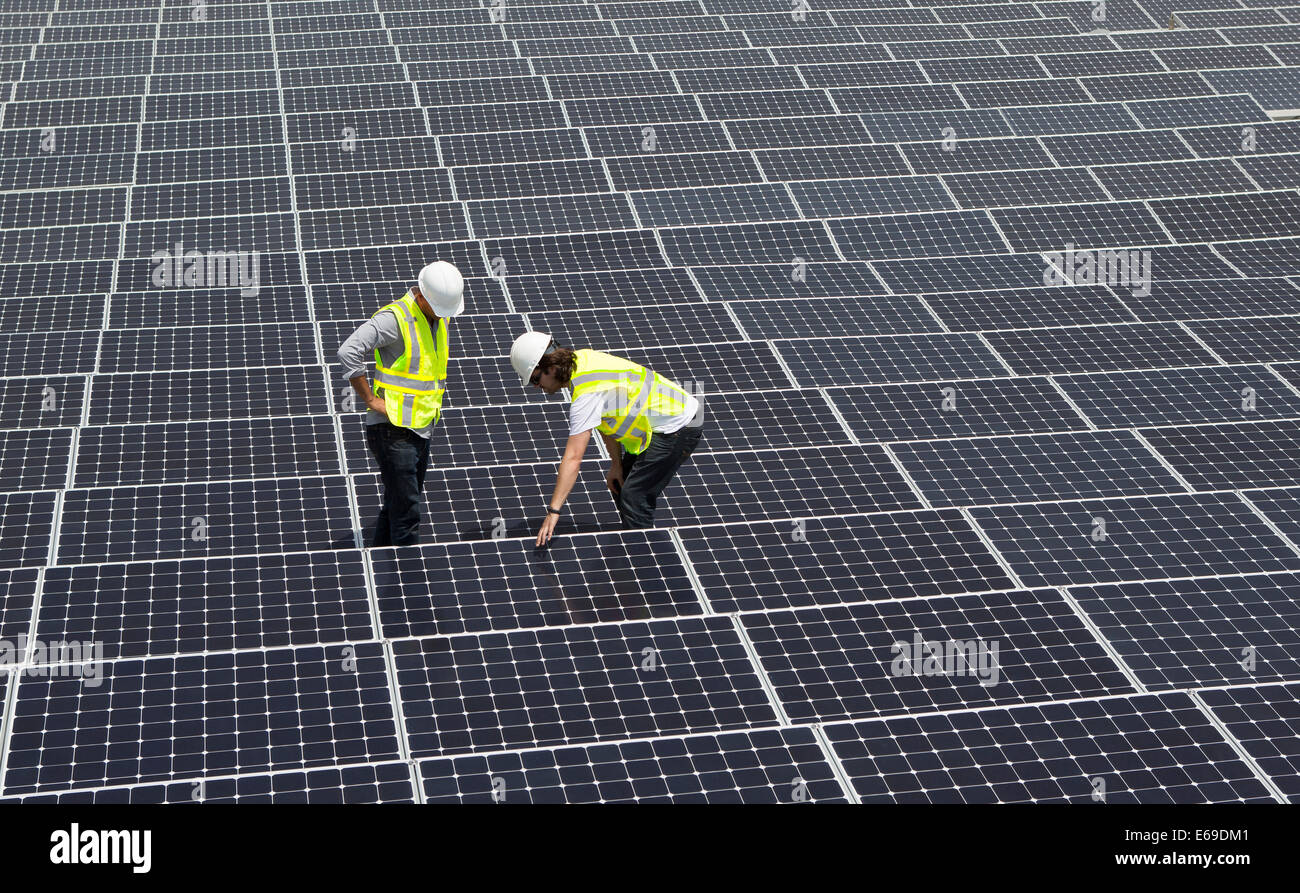 Techniker arbeiten an Sonnenkollektoren Stockfoto