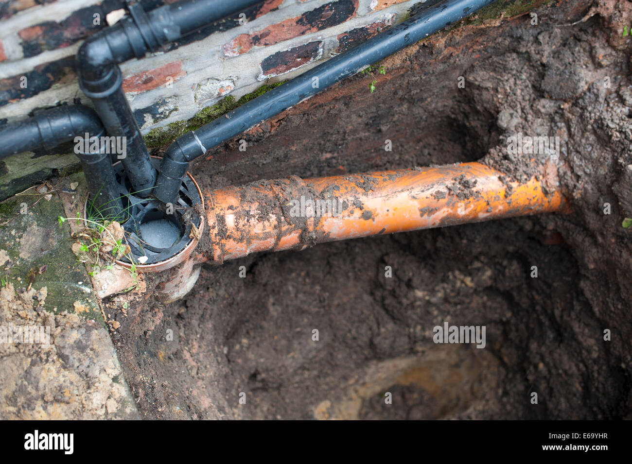 Ausgrabung zu inländischen Kanalisation für vermuteten Leckage zeigt Kunststoff Abfluss und Haus Stiftungen aussetzen Stockfoto