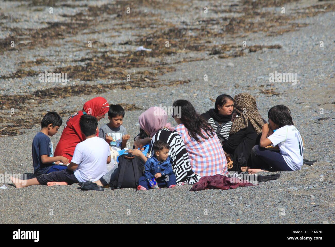 Eine asiatische Familie auf Aberystwyth Strand und genießen Sie ein Picknick Stockfoto