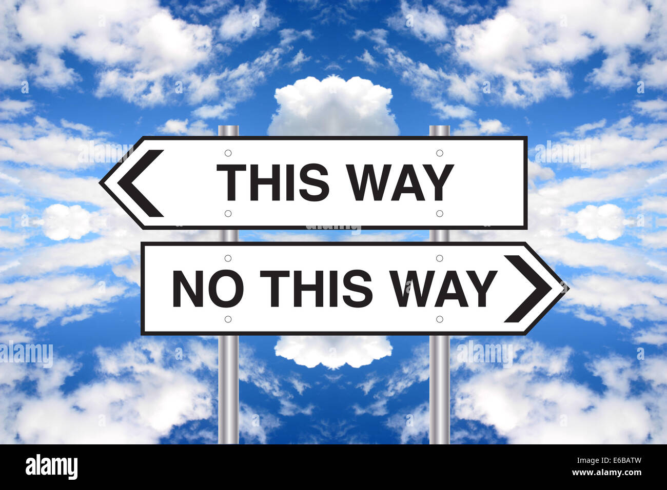 Verwirrende Wegweiser gegen bewölktem Himmel abstrakt. Stockfoto