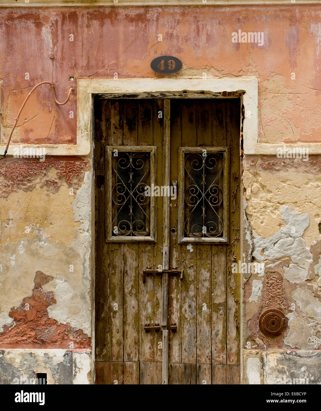 Antike Holztür in einem Haus mit abgenutzten Steinmauer Textur. Stockfoto