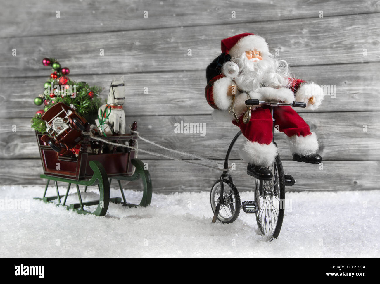 Lustige Weihnachtsgrußkarte mit dem Weihnachtsmann auf einem Fahrrad