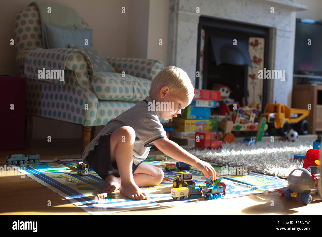 Drei 3 Jahre alter Junge spielt mit seinem Spielzeug im Wohnzimmer ein Wohnhaus, England, UK Stockfoto