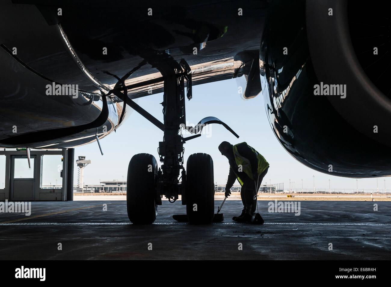 Mann arbeitet auf dem Fahrgestell eines Flugzeugs, Flughafen Berlin Brandenburg International BBI, Berlin, Deutschland Stockfoto