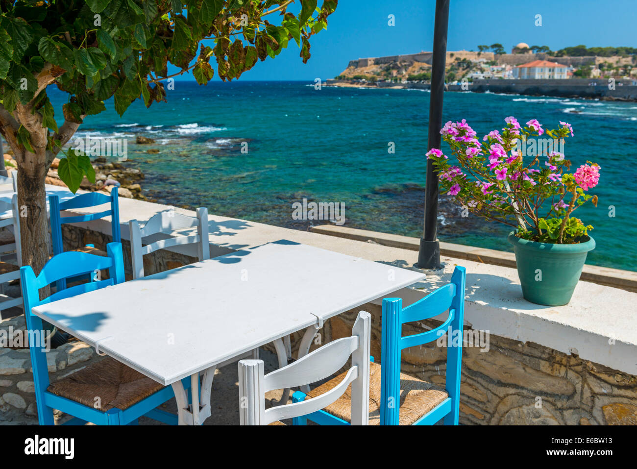 Tisch und Stühle In einer typischen Taverne am Meer in Rethymnon, Kreta, Griechenland Stockfoto