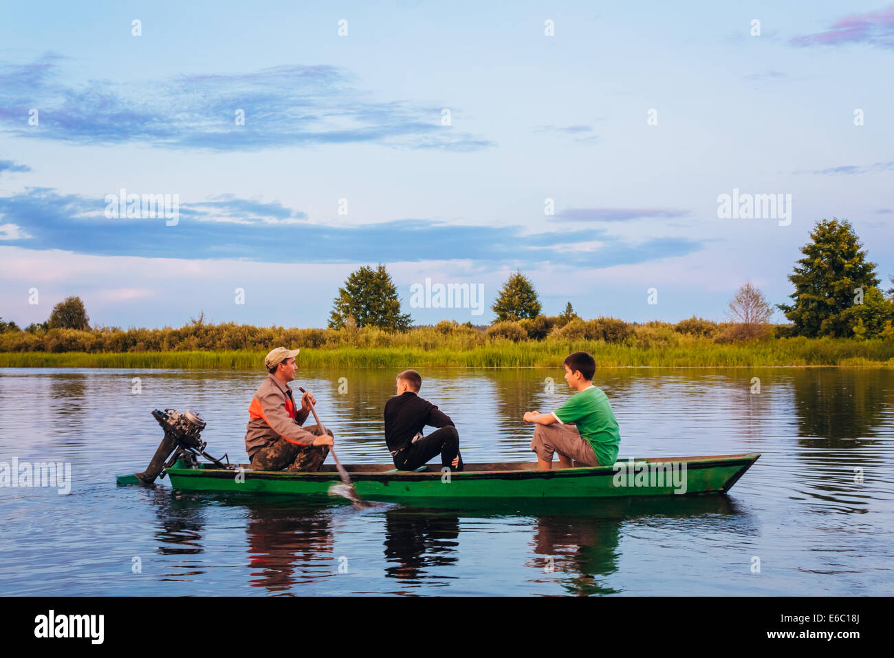 MINSK, BELARUS - 25 Juli: Belarussische Mann und zwei Jungs In alten Segeln Boot am Fluss bei Sonnenuntergang Sommertages am 25. Juli 2013 in M Stockfoto