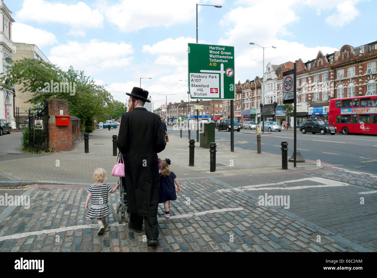 Orthodoxer chassidischer jüdischer Vater, der mit Familienkindern und Kinderwagen durch die Stadt läuft Stoke Newington, Hackney London, Großbritannien KATHY DEWITT Stockfoto
