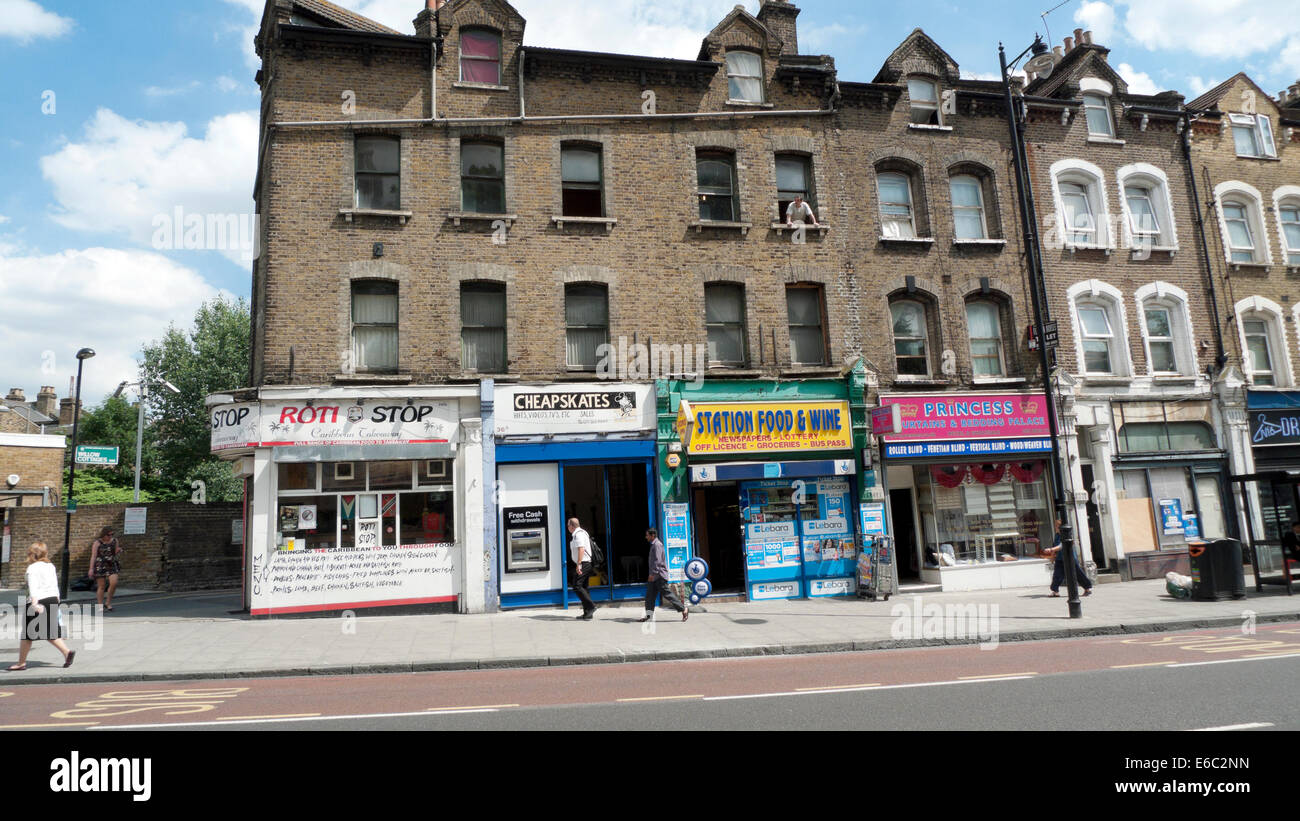 Menschen, die an Reihenwohnungen über kleine Geschäfte auf der Stoke Newington High Street Stamford Hill vorbeigehen London N16 Großbritannien KATHY DEWITT Stockfoto