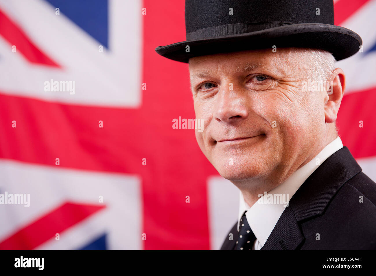 Geschäftsmann, tragen traditionelle britische Melone, und stand vor der Union Jack Flagge des Vereinigten Königreichs. Stockfoto