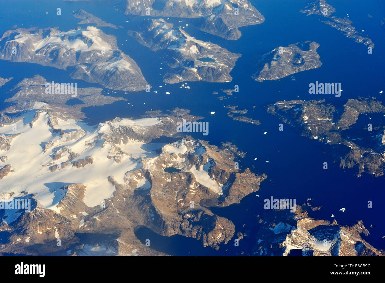 Verschneite Felsinseln und schwimmende Eisberge am Ozean, zwischen Kanada und Grönland Stockfoto