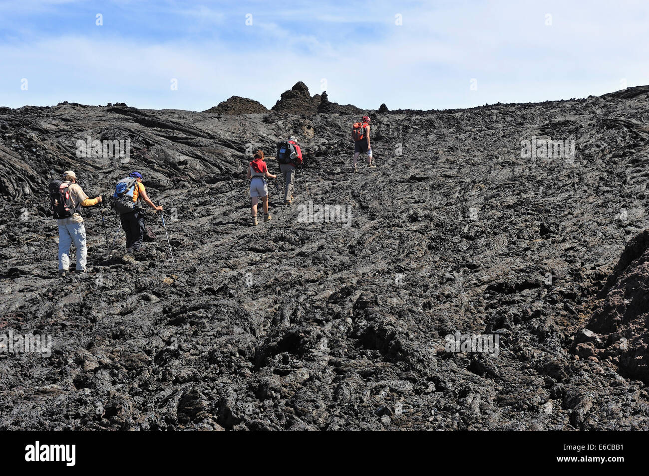 Gruppe von Wanderern zu Fuß auf gekühlte Lava, Vulkan Mauna Loa, Big Island, Hawaii Volcanoes Nationalpark, USA Stockfoto