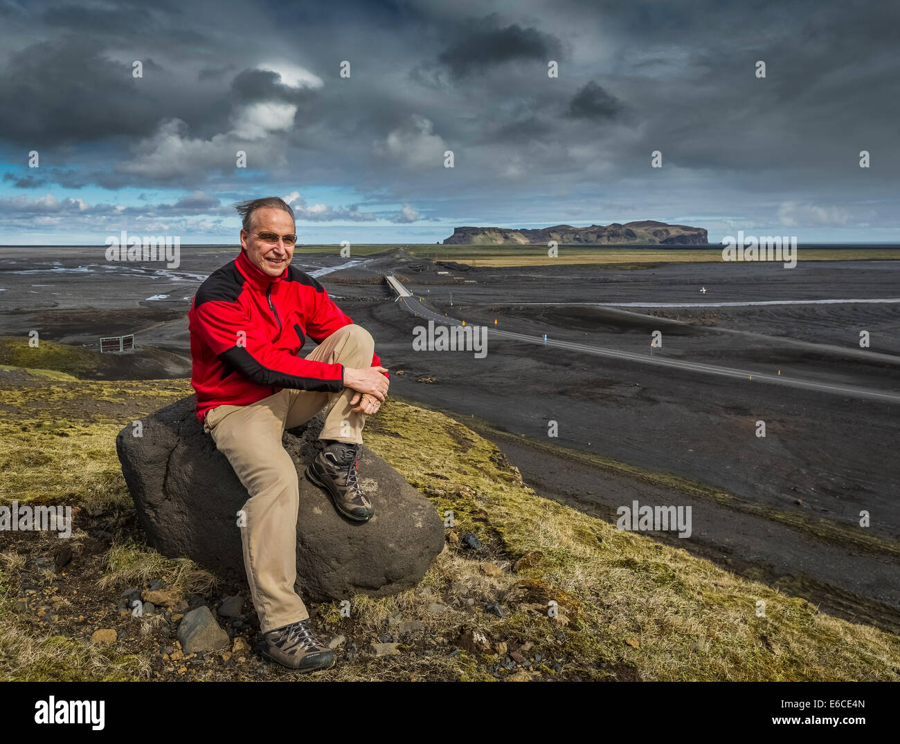 Wissenschaftler, die auf Felsen von Hofdabrekka mit Blick auf Myrdalssandur Sander Ebenen sitzen. Stockfoto