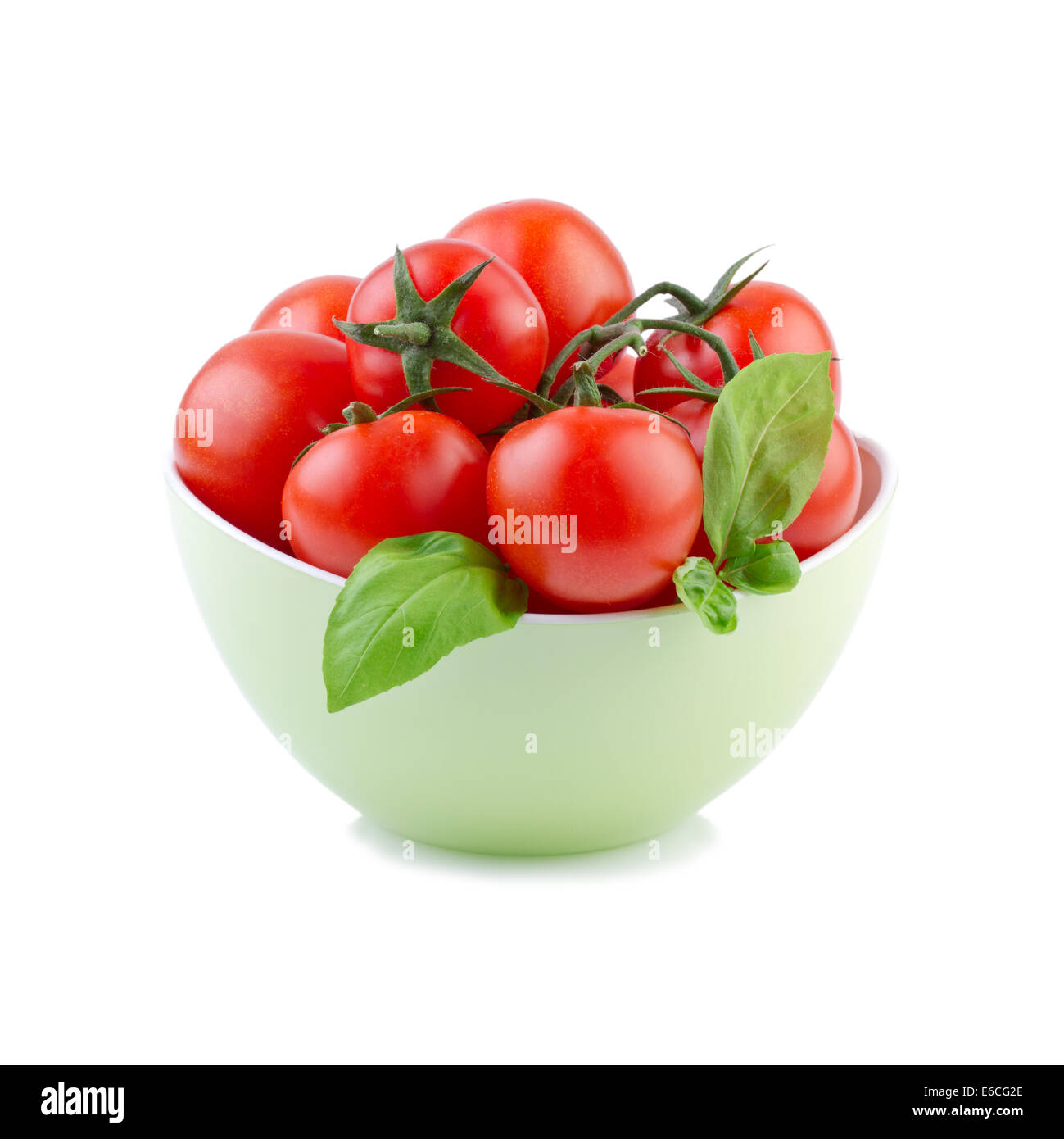 Tomaten mit Basilikum Blätter in grün Schüssel Stockfoto