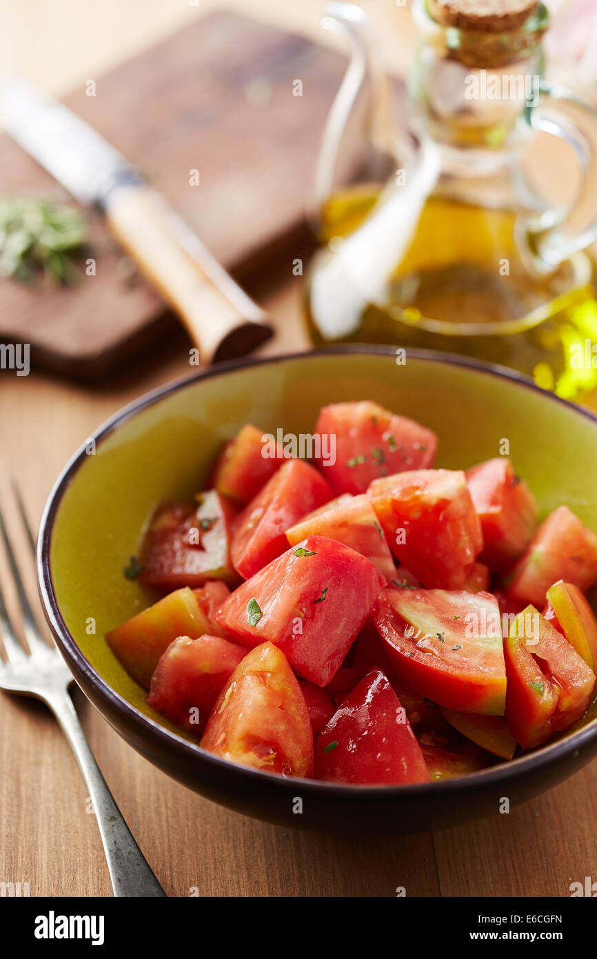 Schüssel mit rohen Tomaten-Salat mit Olivenöl und Kräutern Stockfoto