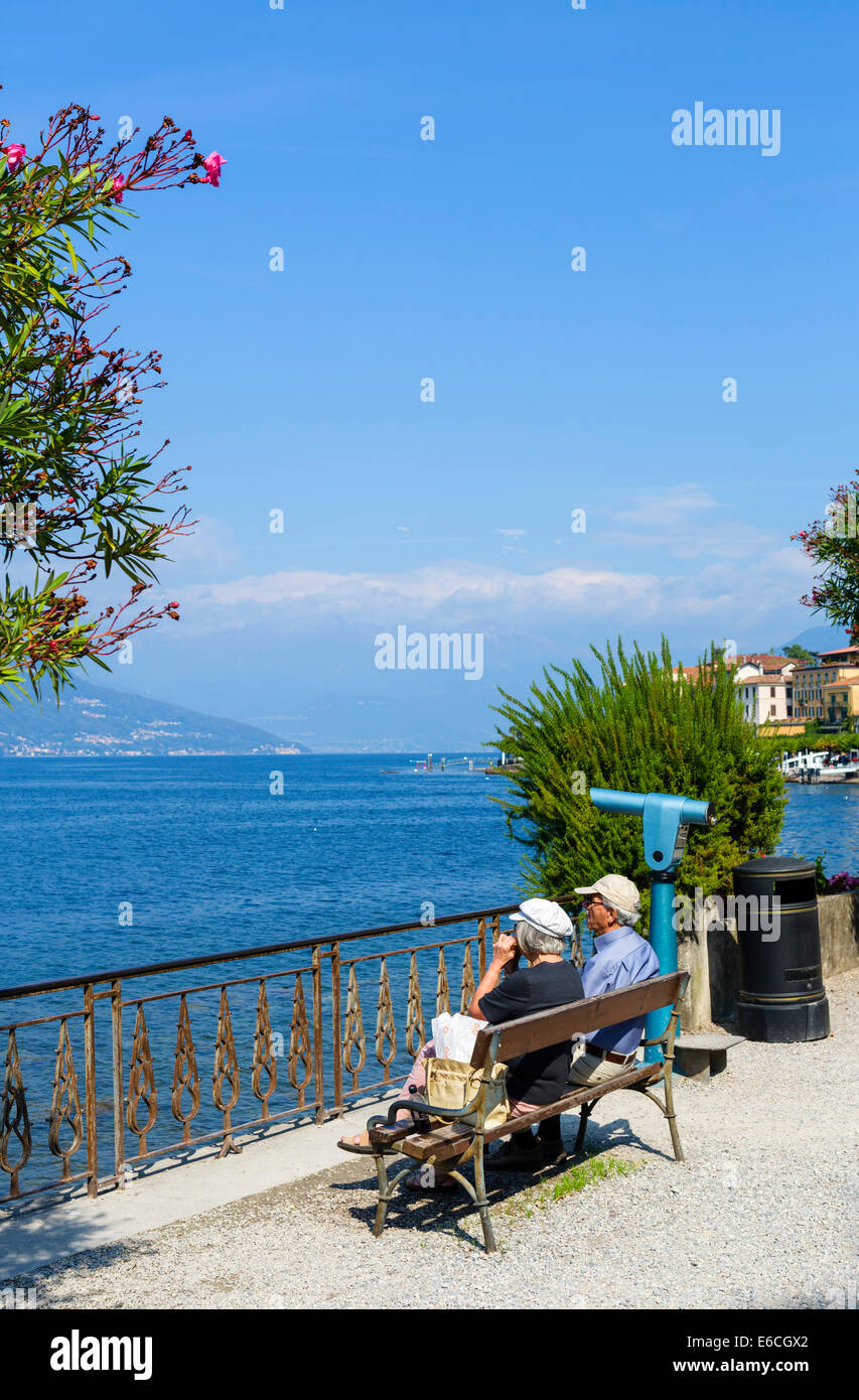 Älteres Ehepaar sitzen beim Mittagessen am Seeufer in Bellagio, Comer See, Lombardei, Italien Stockfoto
