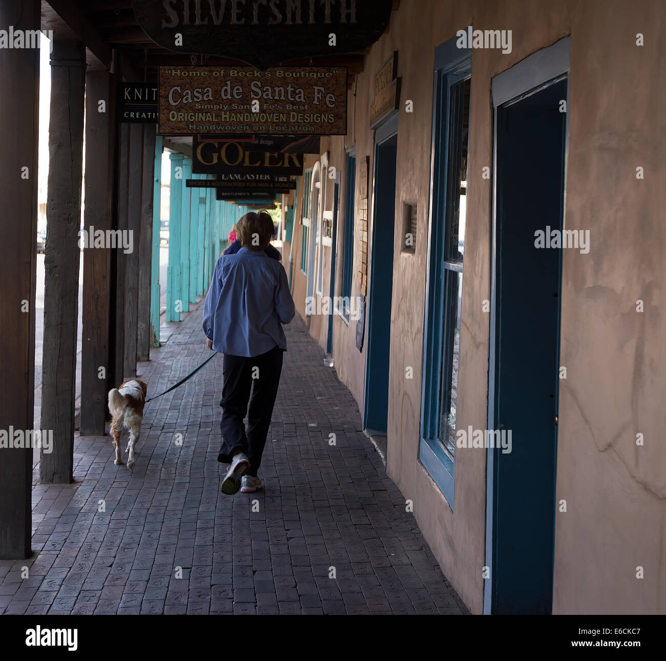 Frau, die ihren Hund spazieren gehen, im historischen Stadtzentrum von Santa Fe, New Mexico Stockfoto