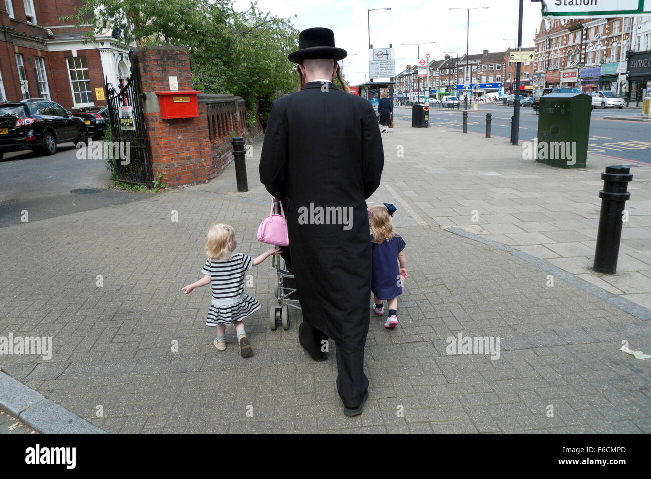 Orthodoxer chassidischer jüdischer Vater, der mit Familienkindern und Kinderwagen durch die Stadt läuft Stoke Newington, Hackney London, Großbritannien KATHY DEWITT Stockfoto