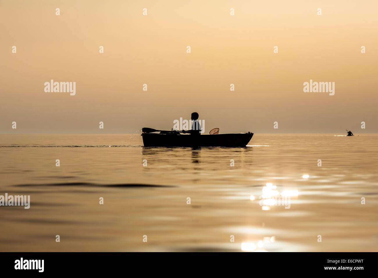 Junge paddeln in den Sonnenuntergang. Stockfoto