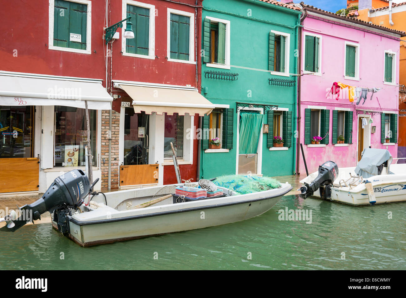 Motor Boote vertäut vor den bunten Häusern der Hauptkanal der Insel Burano in der venezianischen Lagune. Stockfoto