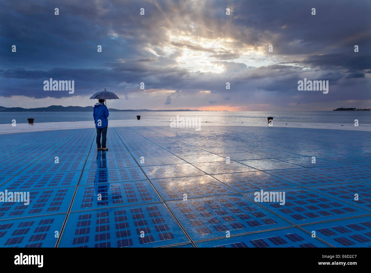 Frau mit Regenschirm, stehend auf der solar Kunstinstallation "Gruß an die Sonne", Zadar, Dalmatien, Kroatien Stockfoto
