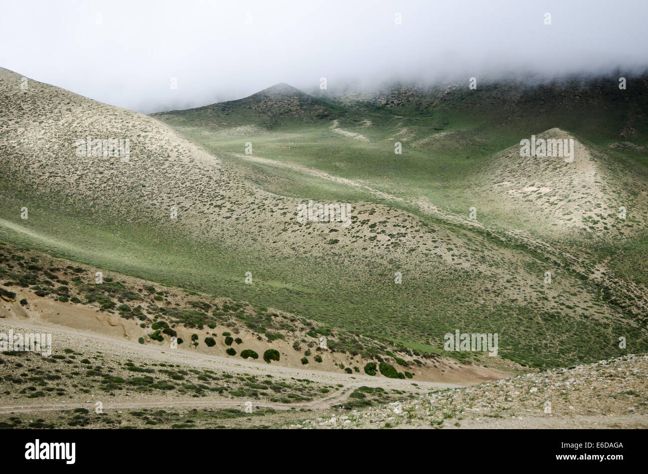 Wolken bewegen sich bis ins Hochgebirge grüne Tal entlang der gewundenen Strecke von Ghemi nach Lo Manthang, Upper Mustang Stockfoto