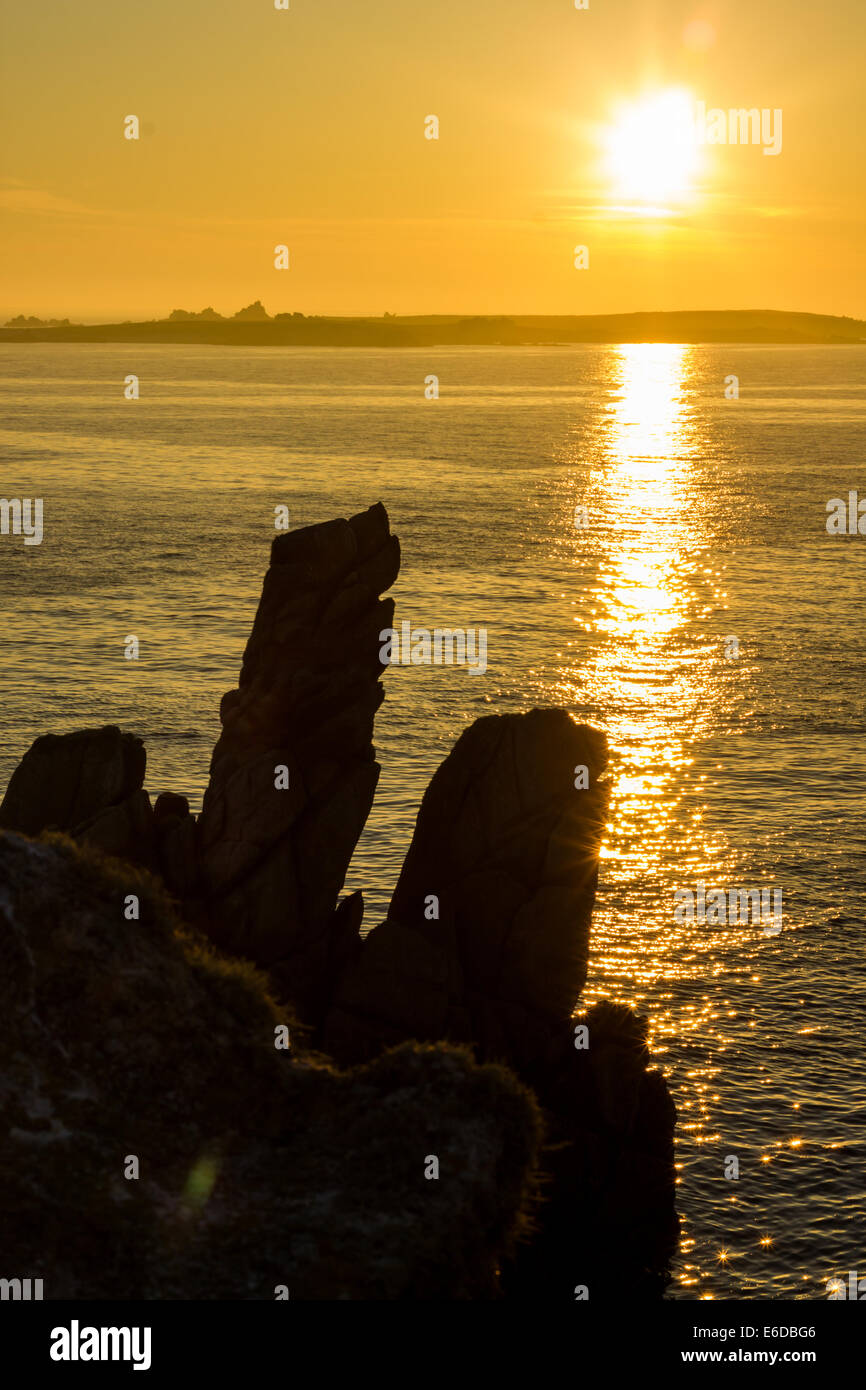 Felsformationen an der Küste von St. Agnes Silhouette gegen die Sonne, wie es über die Insel von annett. Stockfoto