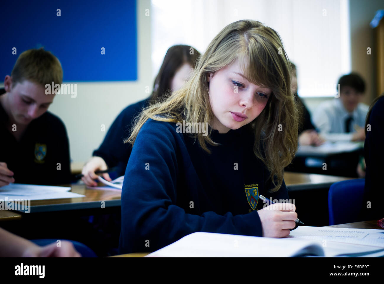 Schulmädchen liest Buch an der Sekundarschule in Cirencester, Großbritannien Stockfoto