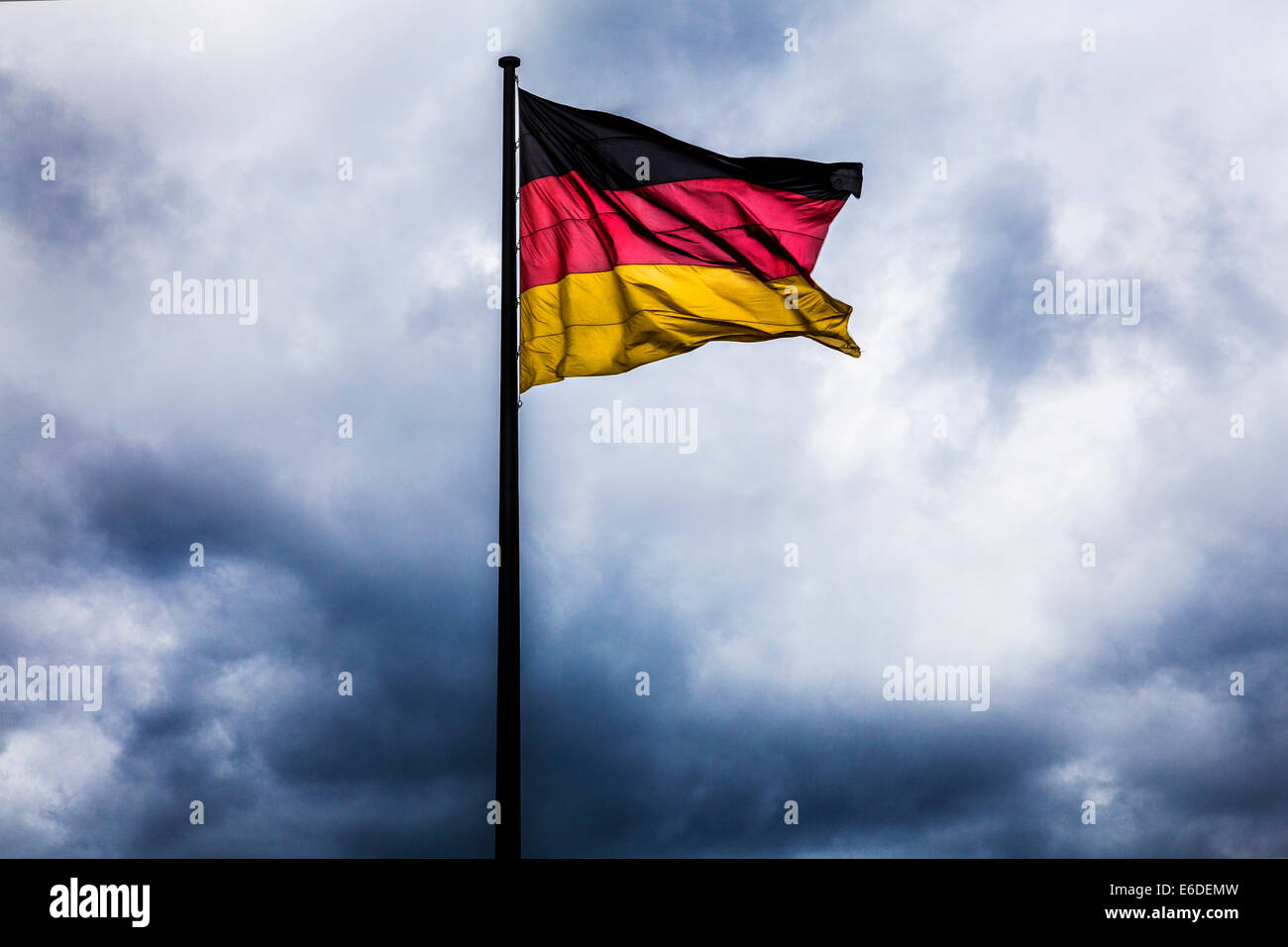 Gewitterwolken hinter die deutsche Flagge, Symbol der politischen Krise, Krieg oder Unruhen zu sammeln. Stockfoto