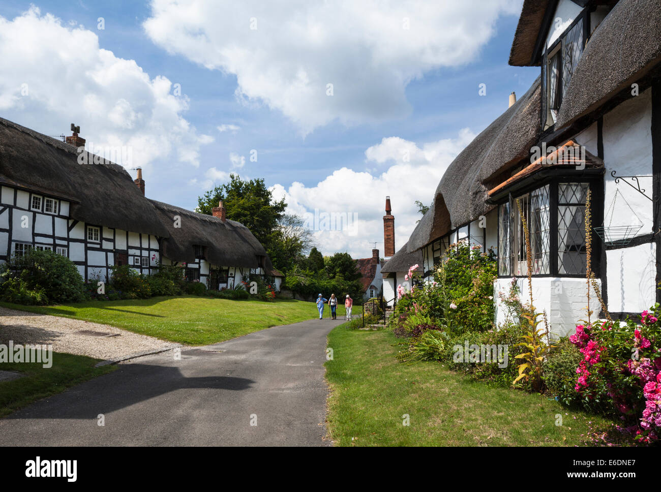 Drei Dame Wanderer zu Fuß vorbei an den Fachwerk- und strohgedeckten Hütten Boot Lane an einem Sommertag in Welford-on-Avon, Warwickshire, England Stockfoto