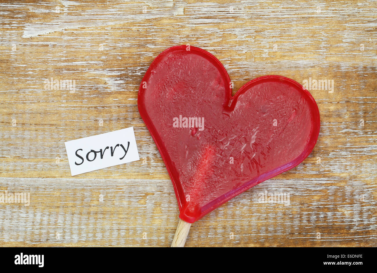 Tut mir leid Karte mit Herz geformten Lollipop auf Holzuntergrund Stockfoto