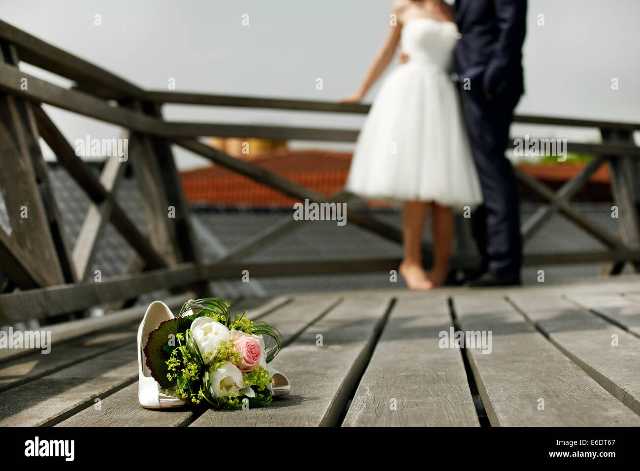 Brautstrauß mit Braut und Bräutigam auf einem Holzdeck Stockfoto