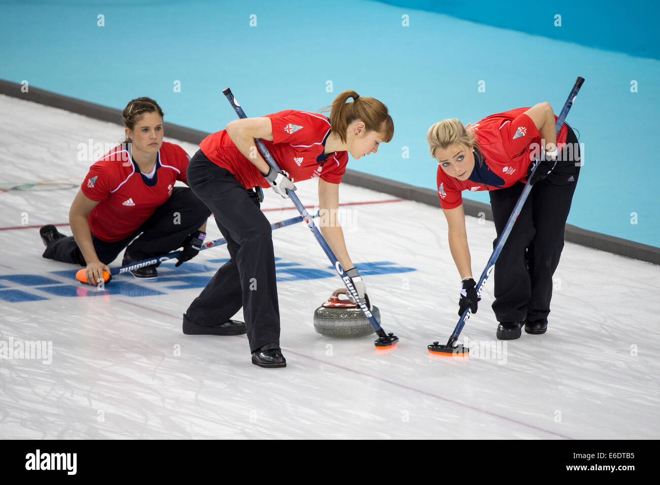 Vicki Adams (r) spielt einen Stein als Claire Hamilton (C) und Anna Sloan Team Great Britain fegen während Damen-Curling-compe Stockfoto