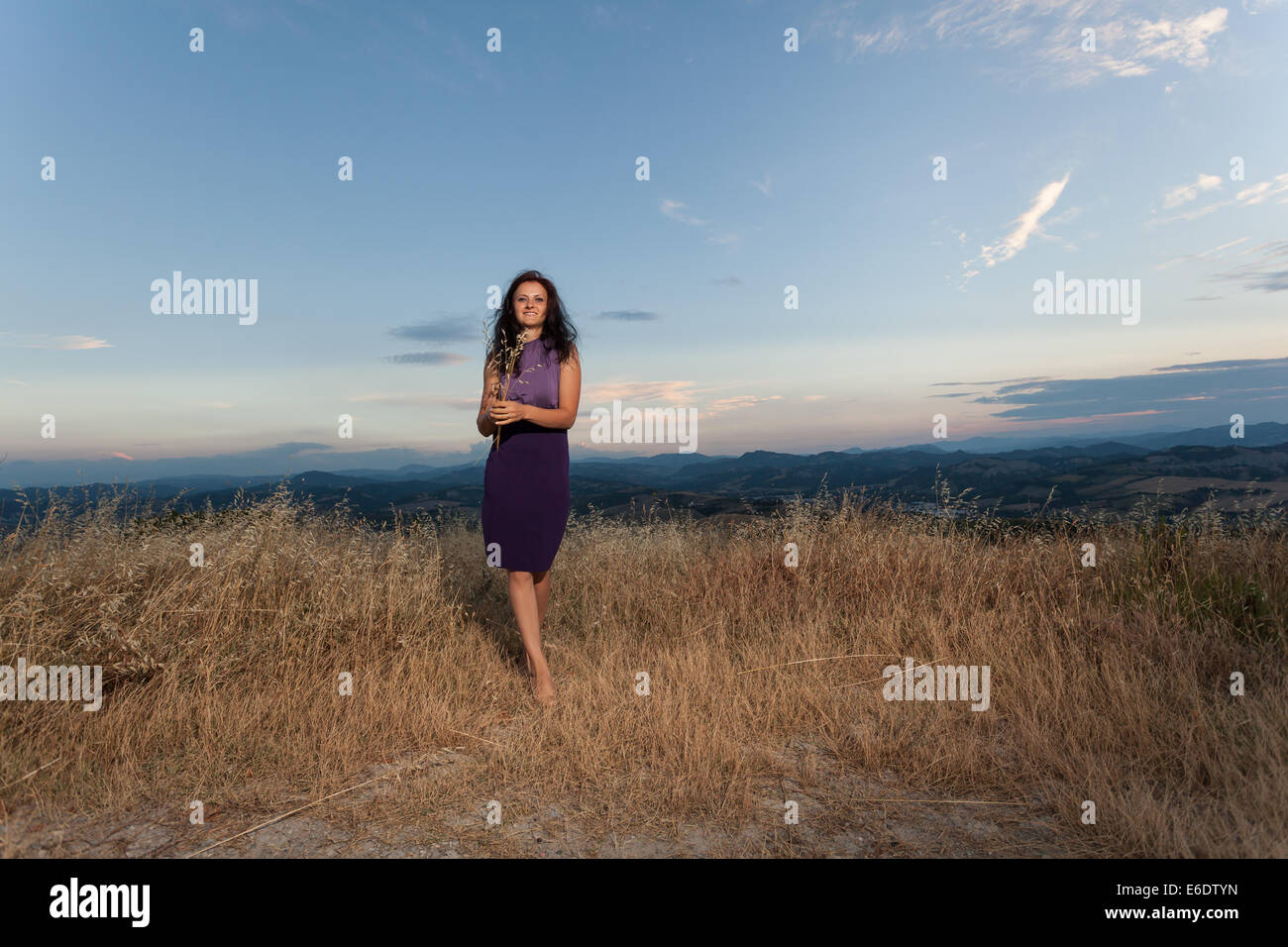 Kaukasischen Frau in lila Kleid im Feld Stockfoto
