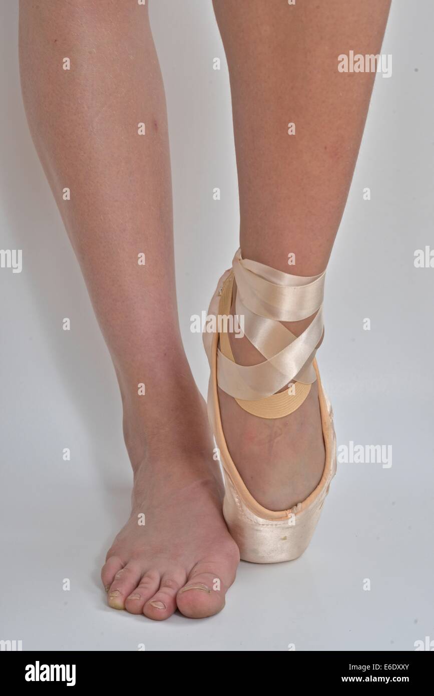 Füße einer Ballerina, eins mit einem Ballett Pointe Schuh und der andere barfuß. Stockfoto