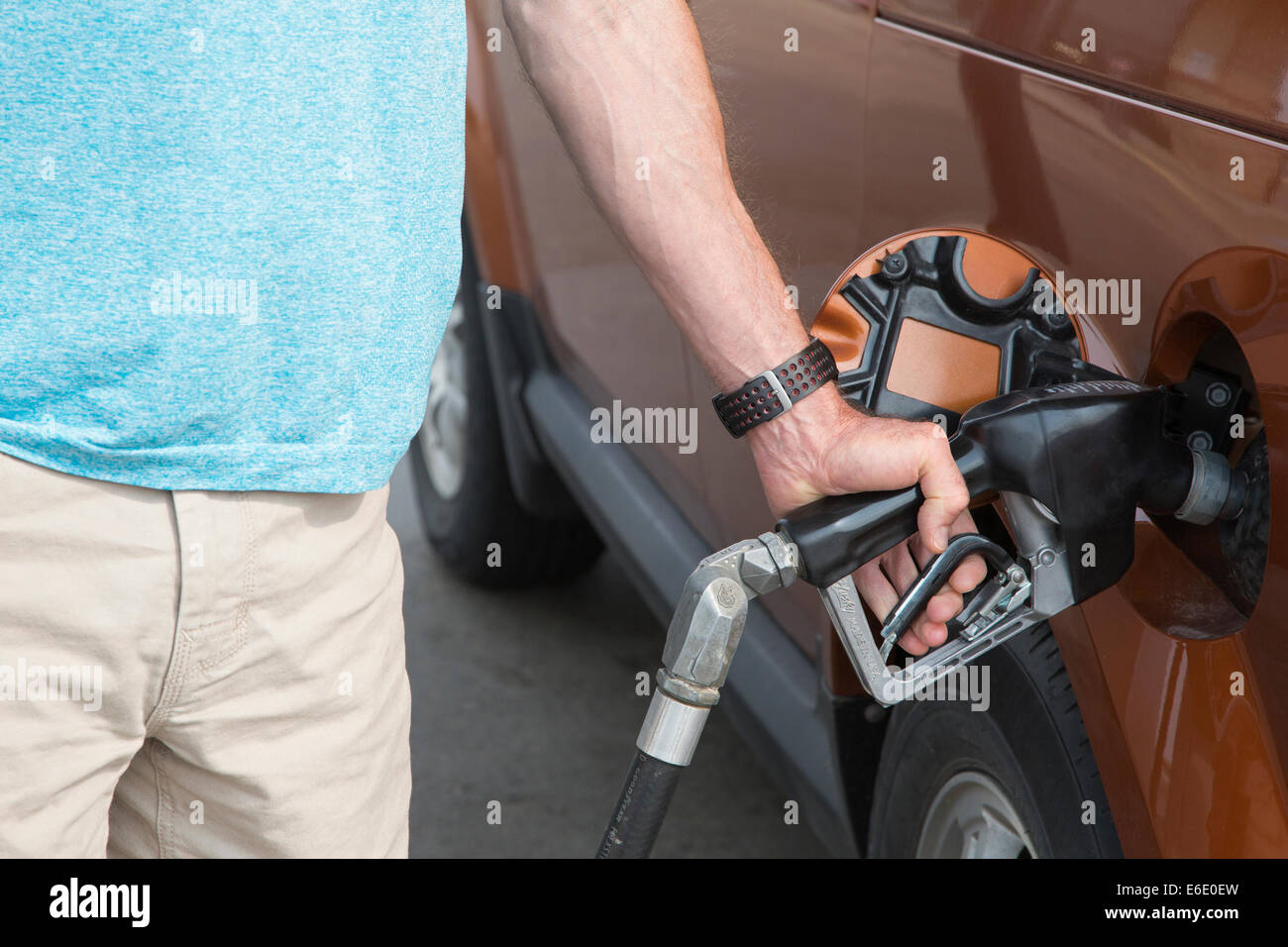 Man pumpt Kraftstoff in sein Fahrzeug an Tankstelle Stockfoto